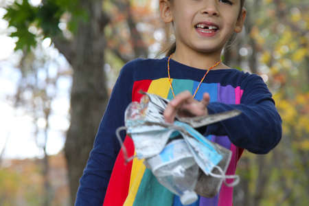 Little girl collecting litter in the woods stock in fallの写真素材