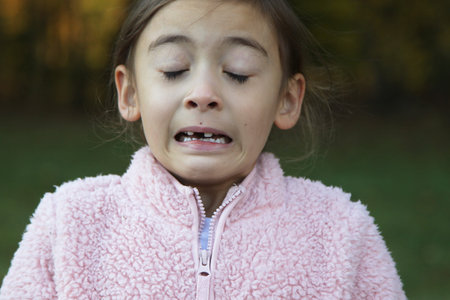 A girl sneezing and coughing from cold and flu, allergy, virus, or hay fever.