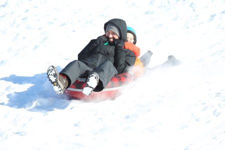 Families went snow sledding at McClennen Park, Arlington, Massachusetts, US on Jan 30, 2022 after the historical snowstormのeditorial素材