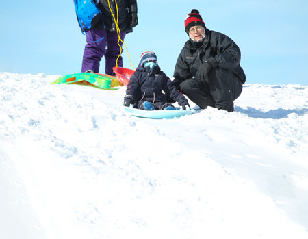 Families went snow sledding at McClennen Park, Arlington, Massachusetts, US on Jan 30, 2022 after the historical snowstormのeditorial素材