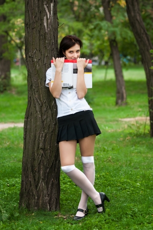 Student standing near a tree with a bookの写真素材