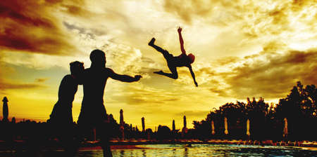 Boy jumps in the pool. Boys having fun and Teen jumps in the pool during the sunsetの写真素材