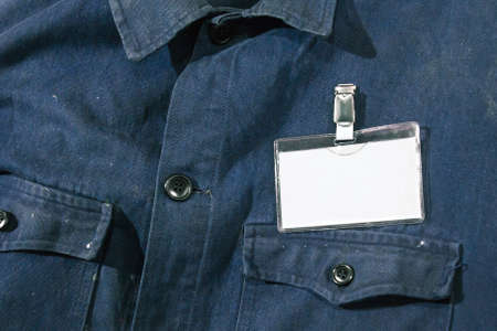 Blank badge on workman's jacket. Dirty blue jeans jacket whith a blank plastic card.の写真素材