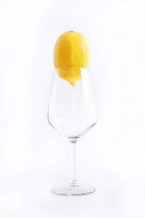 Empty wine glass with lemon, the object is on white backgroundの写真素材