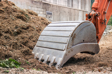 working digger in a construction site, closeup of heavy equipment
