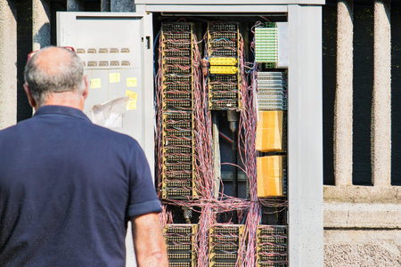 man working on network cabine, operator looking cables