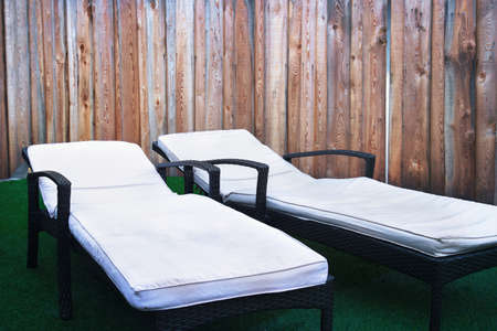 deckchairs, wicker object with pillows on wooden backgroundの写真素材