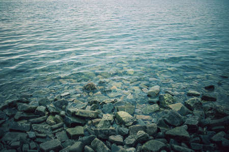 background image of sea waves on rocks, view of water in winter seasonの写真素材