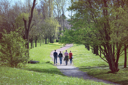 Double date at the park. Four people walking outdoor enjoying springtimeの写真素材