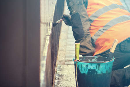man working on the gray wall, man working on the street (copy space on the left)の写真素材