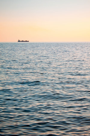 a boat with a ship on the horizonの写真素材