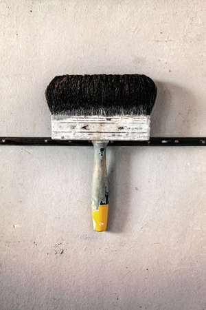 black rustic hanging brush, old rusty tool for painting on a grunge backgroundの写真素材