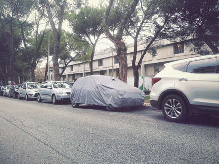 Protective car cover. Sunlight, rain and dust protection (the vehicle is parked on a public road)の写真素材