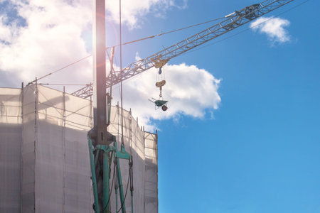 Crane in a construction site with copy space, the machinery is moving a work toolの写真素材