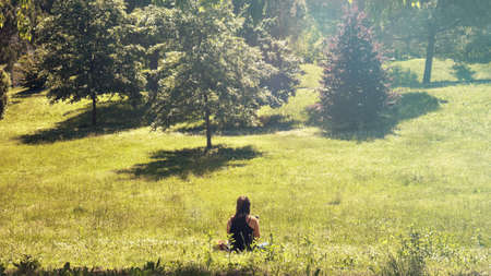 girl relaxing on the meadow, lonely woman enjoys the natureの写真素材