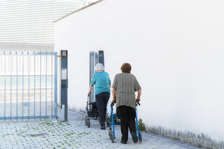 senior women using walker, two old ladies go into the retirement home (copy space available on the right)の写真素材