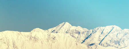 vintage picture of mountain landscape with snow and blue sky, extreme horizontal sizeの写真素材