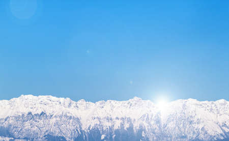 brightness light in mountain landscape with snow and blue sky, background horizontal pictureの写真素材