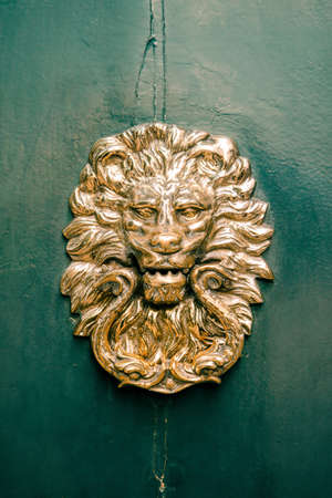 decorative golden lion at the door, vintage object on green doorの写真素材