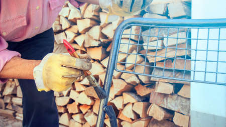 Man using brush to paint an object. Worker in backyard painting a chairの写真素材