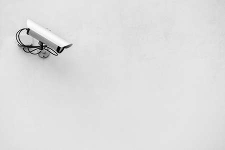 security camera on white wall, surveillance equipment with a lot of copy spaceの写真素材