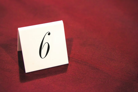 place card with six number, the object is on red tablecloth