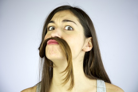 funny girl making mustache of her long hairの写真素材