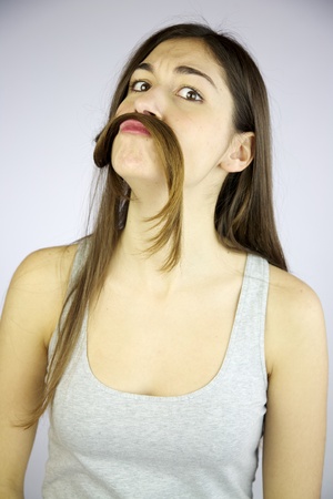 Funny girl making mustache with her very long hairの写真素材