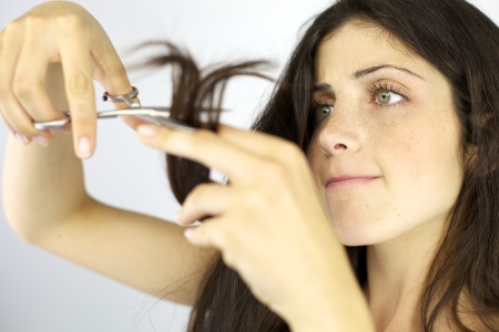 Serious female model ready to cut her long hairの写真素材