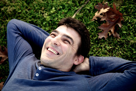 Handsome businessman having fun while relaxing in park in autumn