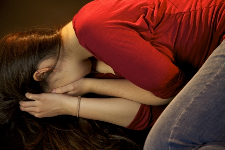 Woman laying on the ground scared of being hit againの写真素材