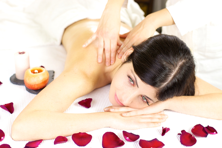 Gorgeous woman relaxing completely with female therapist doing massage on backの写真素材