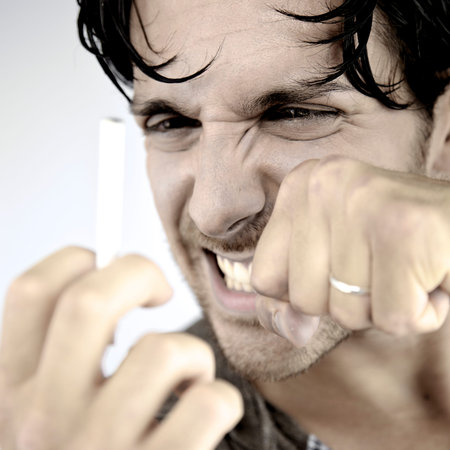 Angry man fighting with cigarette willing to stop smoking