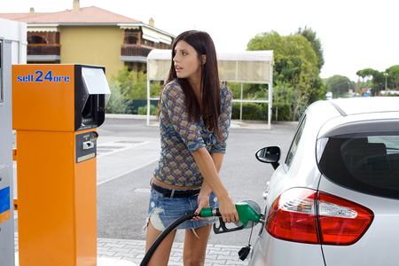 Gorgeous italian lady filling car with green gasの写真素材