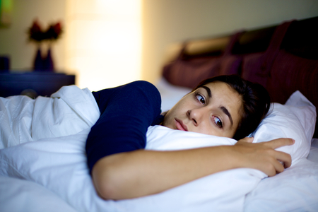 Unhappy woman in bed thinking depressedの写真素材