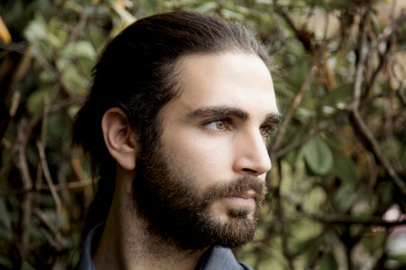 closeup oh serious handsome man with beard and long hair