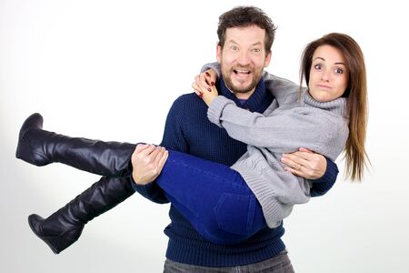 Couple doing funny faces while holding each other isolatedの写真素材