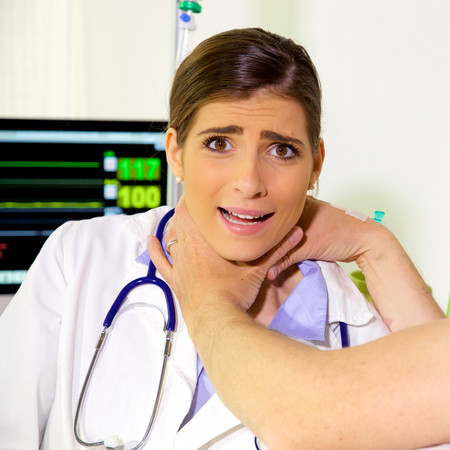 Scared female doctor being strangled in hospitalの写真素材