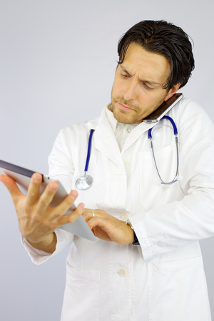 cool doctor working with tablet and phoneの写真素材