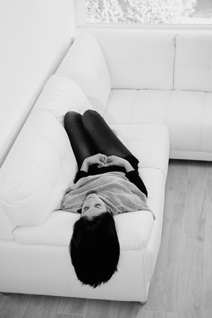 Happy young woman on sofaの写真素材