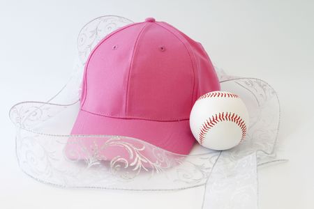 Feminine presentation of a girl's love of baseball; pink cap, white ribbon, and baseball; の写真素材