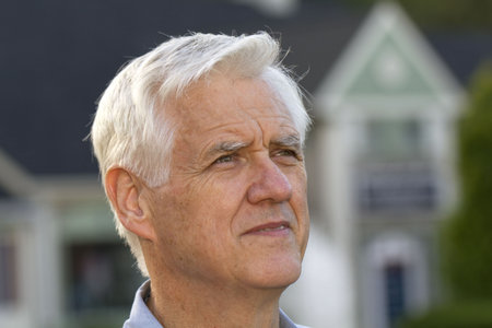Portrait shot of senior man with defocused home outlines behind him reflect the universal effect of...