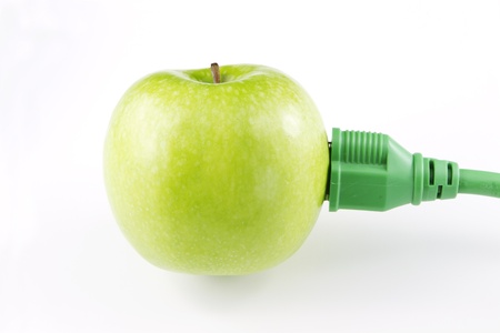Fresh, green apple with green electric plug and cord attached signify a modern, current emphasis on green energy;の写真素材