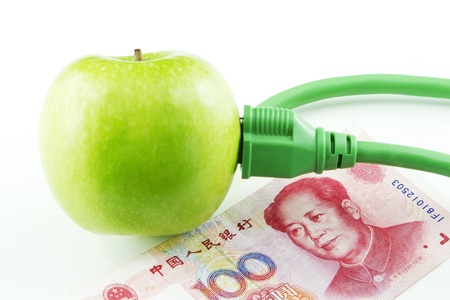 Green apple placed next to Chinese yuan currency emphasize China's fresh support of energy innovationの写真素材