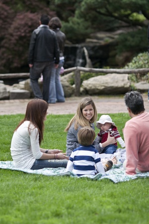 Lahaska, PA, USA - April 30, 2011: Family group relaxes on green grass in the garden-like, shopping environment at Peddler's Village popular, annual Strawberry Festivalのeditorial素材