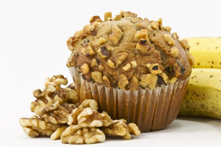 Close up of large, banana and nut muffin surrounded by shelled walnuts and ripe bananasの写真素材