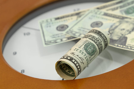American currency placed on face of clock is indicative of time's relationship to money in...