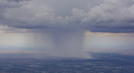 Rain pours onto Albuquerque Airport from clouds over the city.  View as seen from Sandia Crest Highway on scenic byway to peak.の写真素材