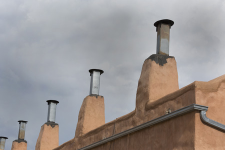 Row of chimneys on adobe building in Old Town district of Albuquerque, New Mexico.  Copy space in sky above architectural details.の写真素材