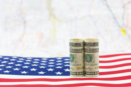 American dollars placed on USA flag with distant map as background.  Economic growth is a national issue.の写真素材